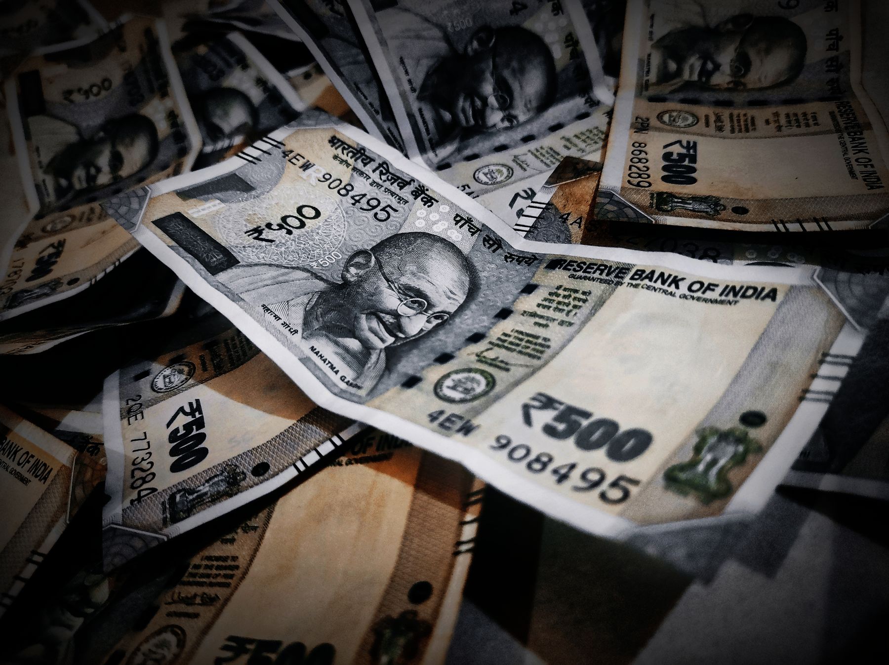 Rupee notes and a notebook laid out on a table
