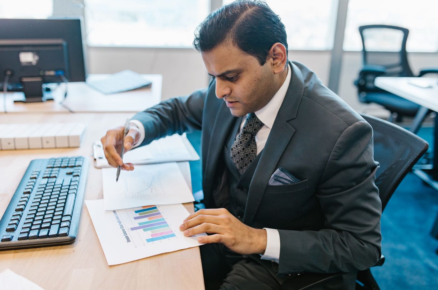 Hands pointing at charts printed on paper during a review