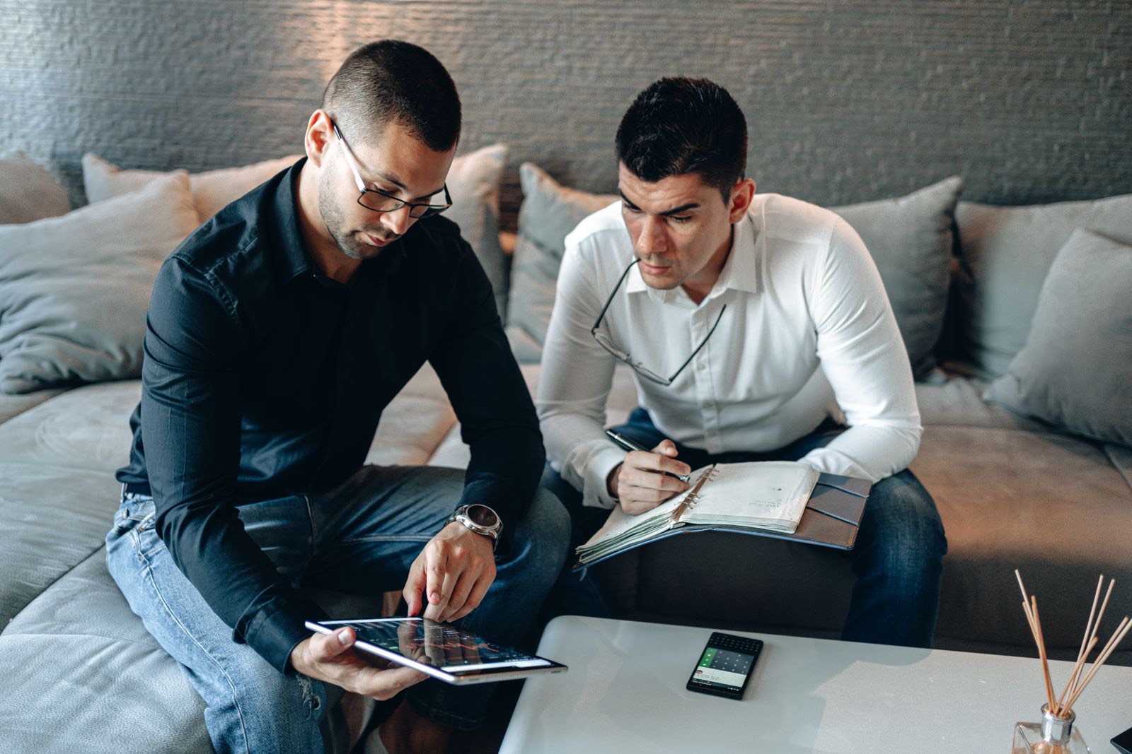 Two people going through investment figures on a tablet