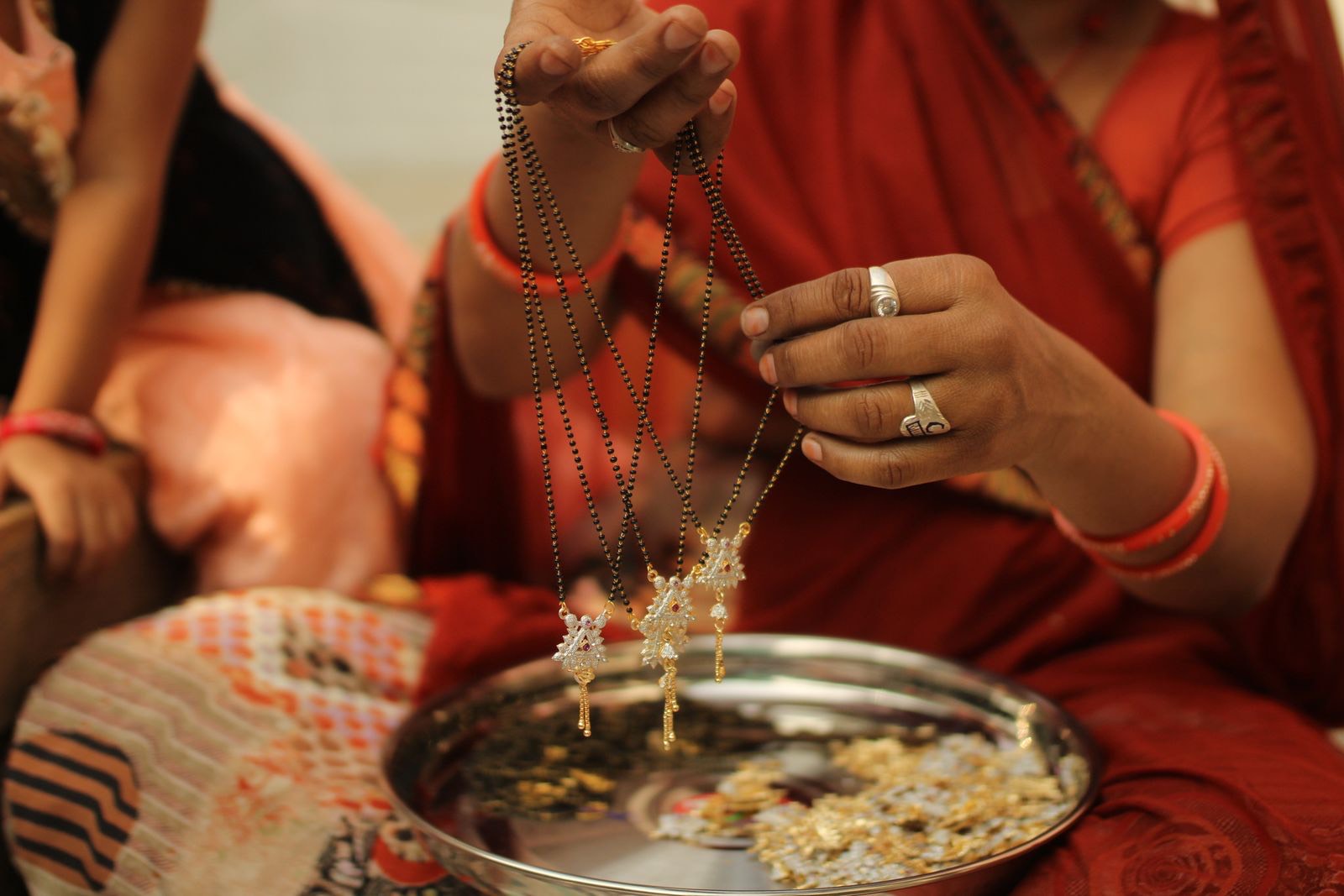 Woman holding gold jewellery over a steel plate