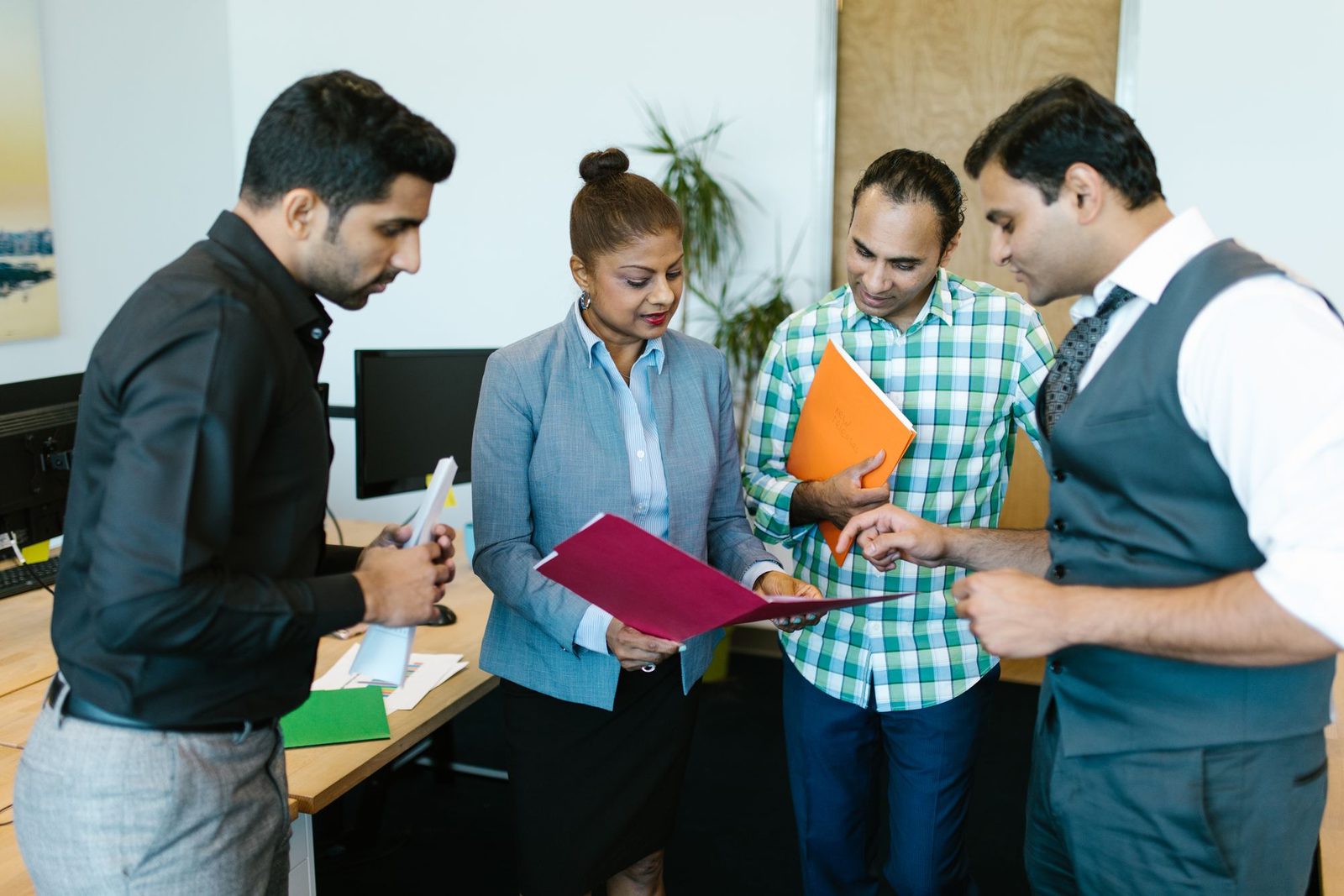Two people going through a printed document, one pointing at a line