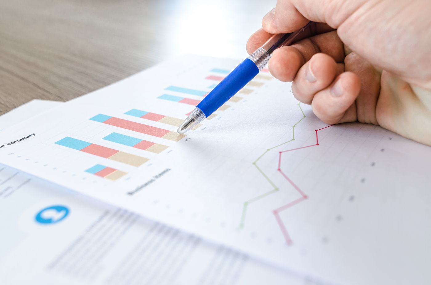 A hand marking figures on a printed fund performance chart
