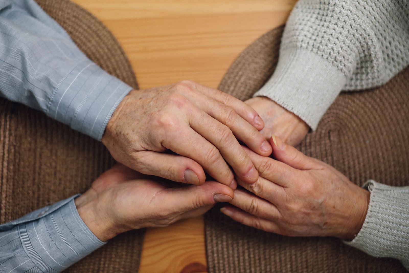 An older couple holding hands across a table