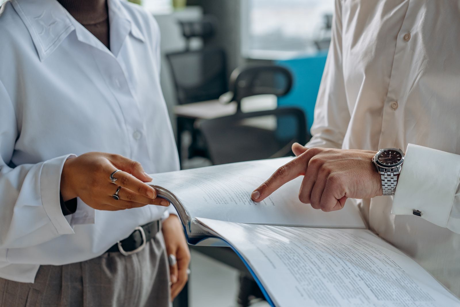 Two people going through a printed report together, one pointing at a line