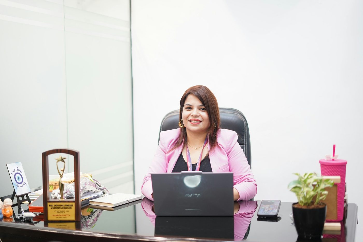 A woman with folded arms smiling at her workplace